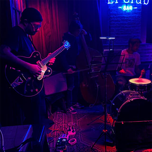 Imagen de Pablo Cúbico, fundador de VOGUM, tocando la guitarra en un club de jazz.